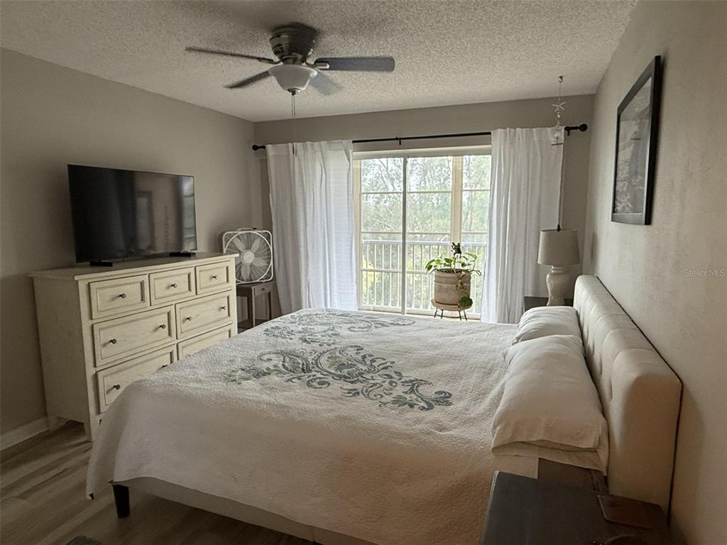 9510 Harbor Greens Way, Unit 407 Seminole, FL 33776 - Photo 17 of 41 a bedroom with a bed and a flat screen tv