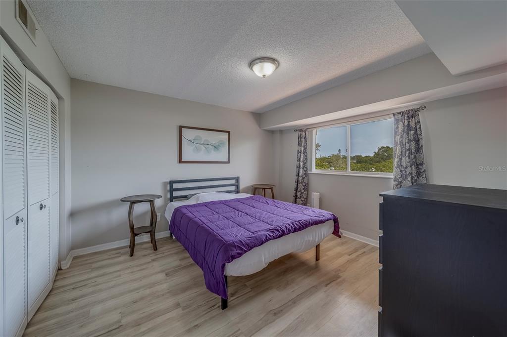 9510 Harbor Greens Way, Unit 407 Seminole, FL 33776 - Photo 19 of 41 a bedroom with a bed and a window