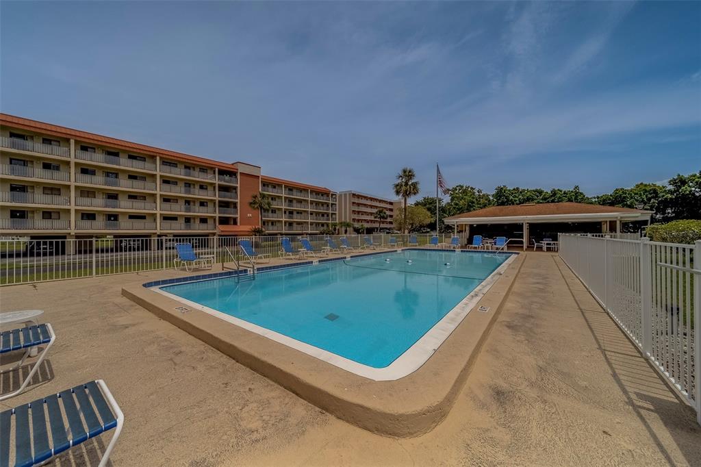 9510 Harbor Greens Way, Unit 407 Seminole, FL 33776 - Photo 2 of 41 a view of a swimming pool with outdoor seating and plants
