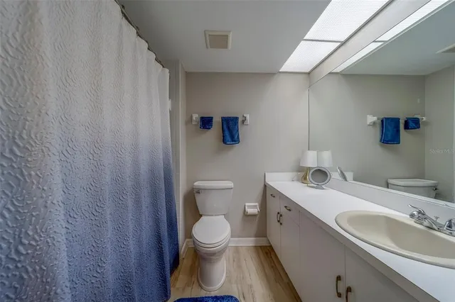 a bathroom with a toilet a sink and mirror