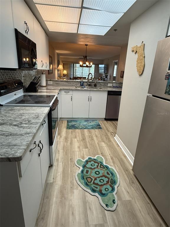 9510 Harbor Greens Way, Unit 407 Seminole, FL 33776 - Photo 7 of 41 a kitchen with a sink a counter top space stainless steel appliances and cabinets