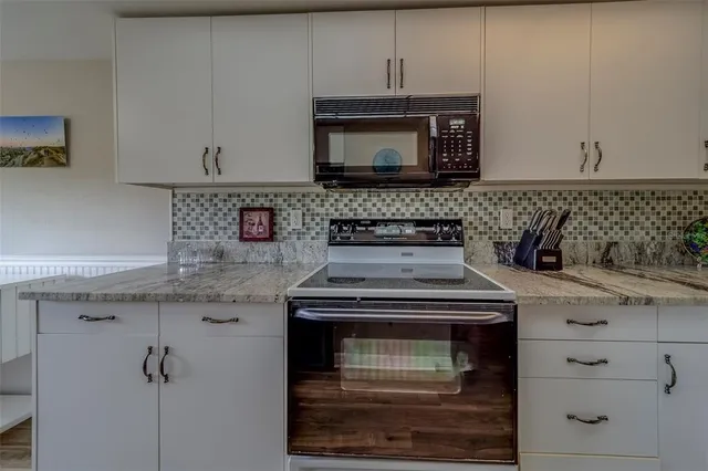 a stove top oven sitting inside of a kitchen