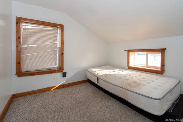 a bed sitting in a bedroom next to a window