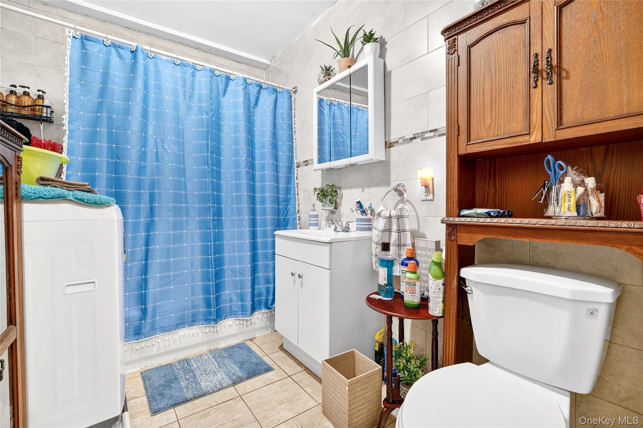 1459 Rosedale Avenue Bronx, NY 10460 - Photo 11 of 37 Bathroom featuring tile walls, vanity, curtained shower, and light tile patterned floors