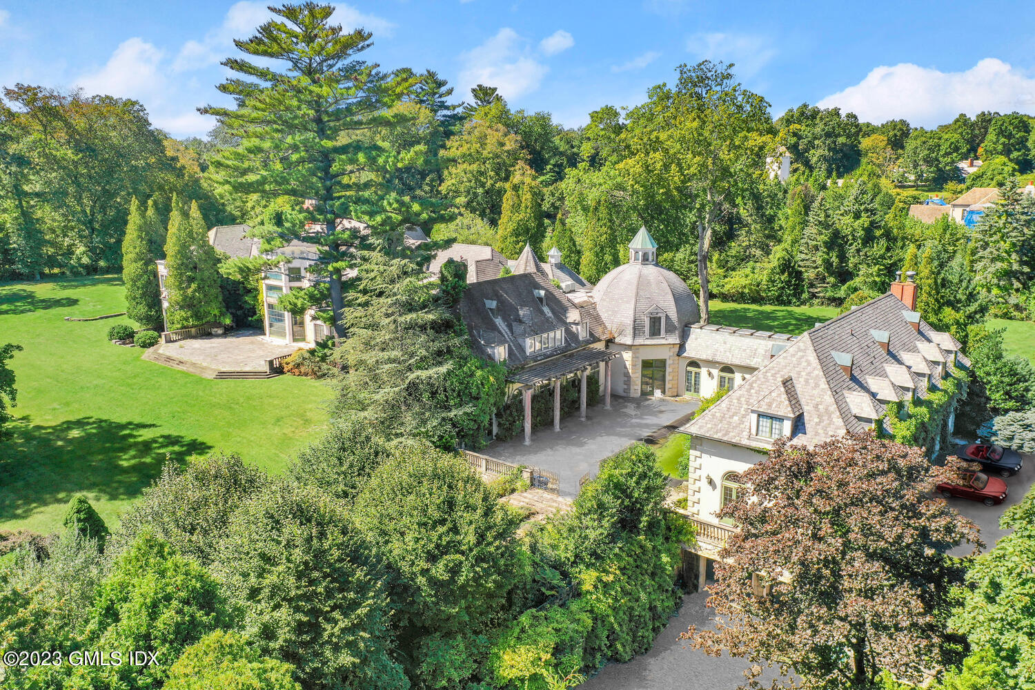 Undisclosed Address Greenwich, CT 06830 - Photo 2 of 5 a view of a patio with table and chairs potted plants and large tree