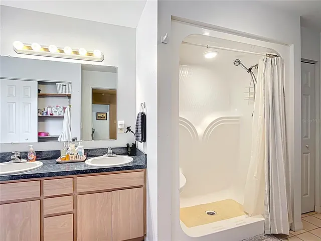 a en suite bathroom with a double vanity sink and a mirror