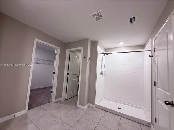 an empty room with a ceiling fan and a window