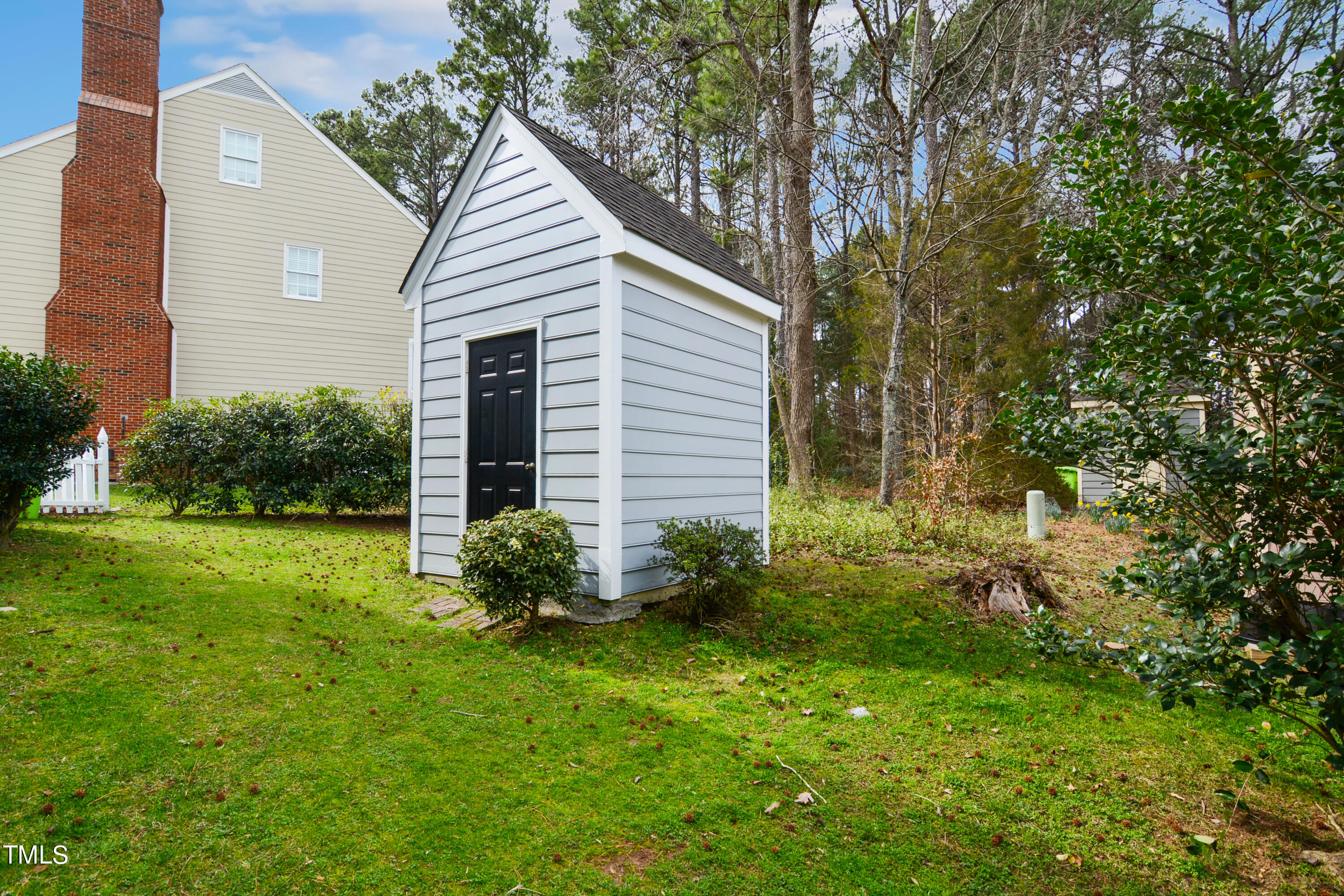 1811 Carrington Drive Raleigh, NC 27615 - Photo 23 of 23 a backyard of a house with plants and large tree