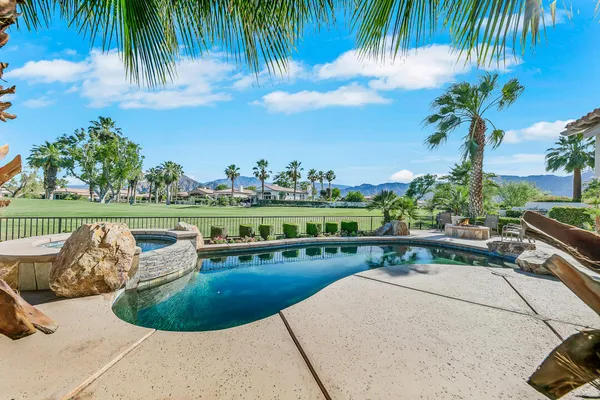 a view of a swimming pool with a patio and plants