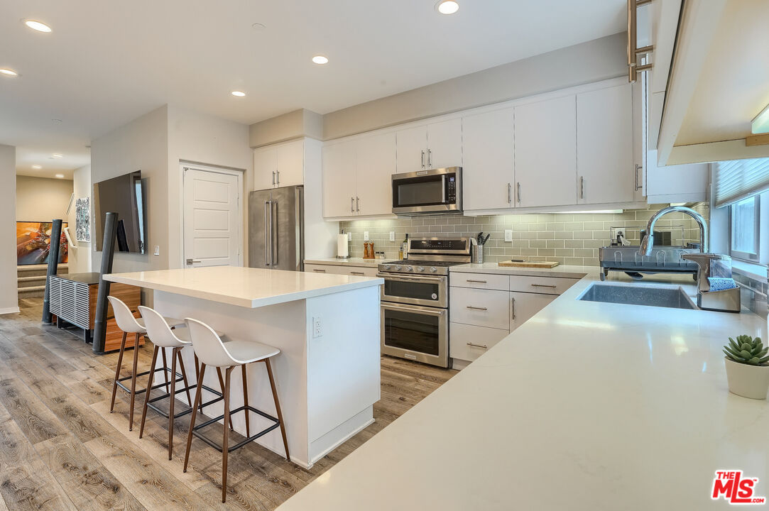 237 Magnet Irvine, CA 92618 - Photo 3 of 34 a kitchen with stainless steel appliances a sink a stove a refrigerator cabinets and a dining table