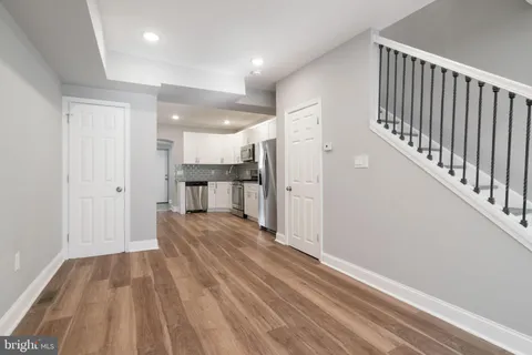 a view of a hallway with wooden floor and kitchen