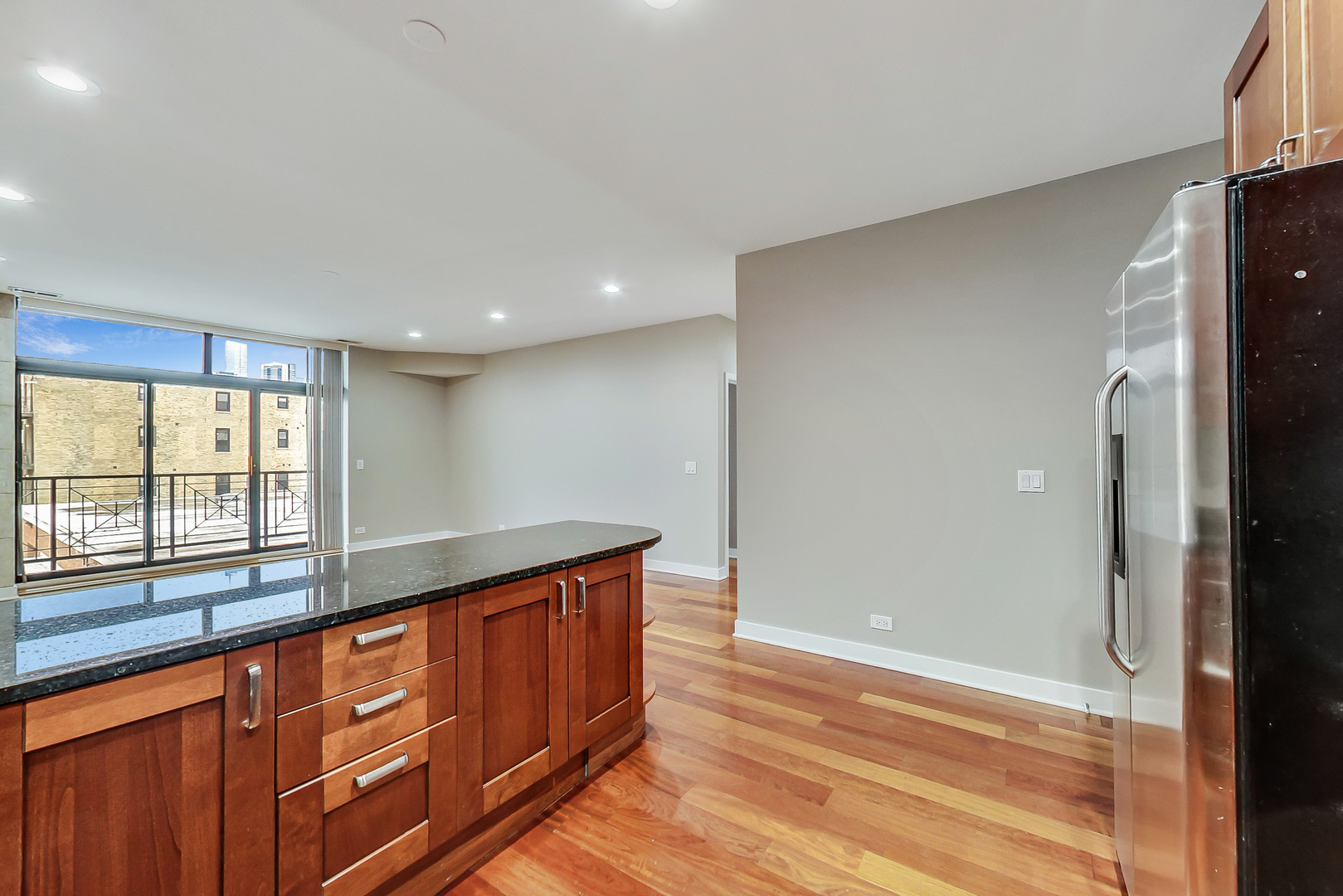 651 North Milwaukee Avenue, Unit 304 Chicago, IL 60642 - Photo 11 of 33 a hallway with stainless steel appliances granite countertop a refrigerator and a sink