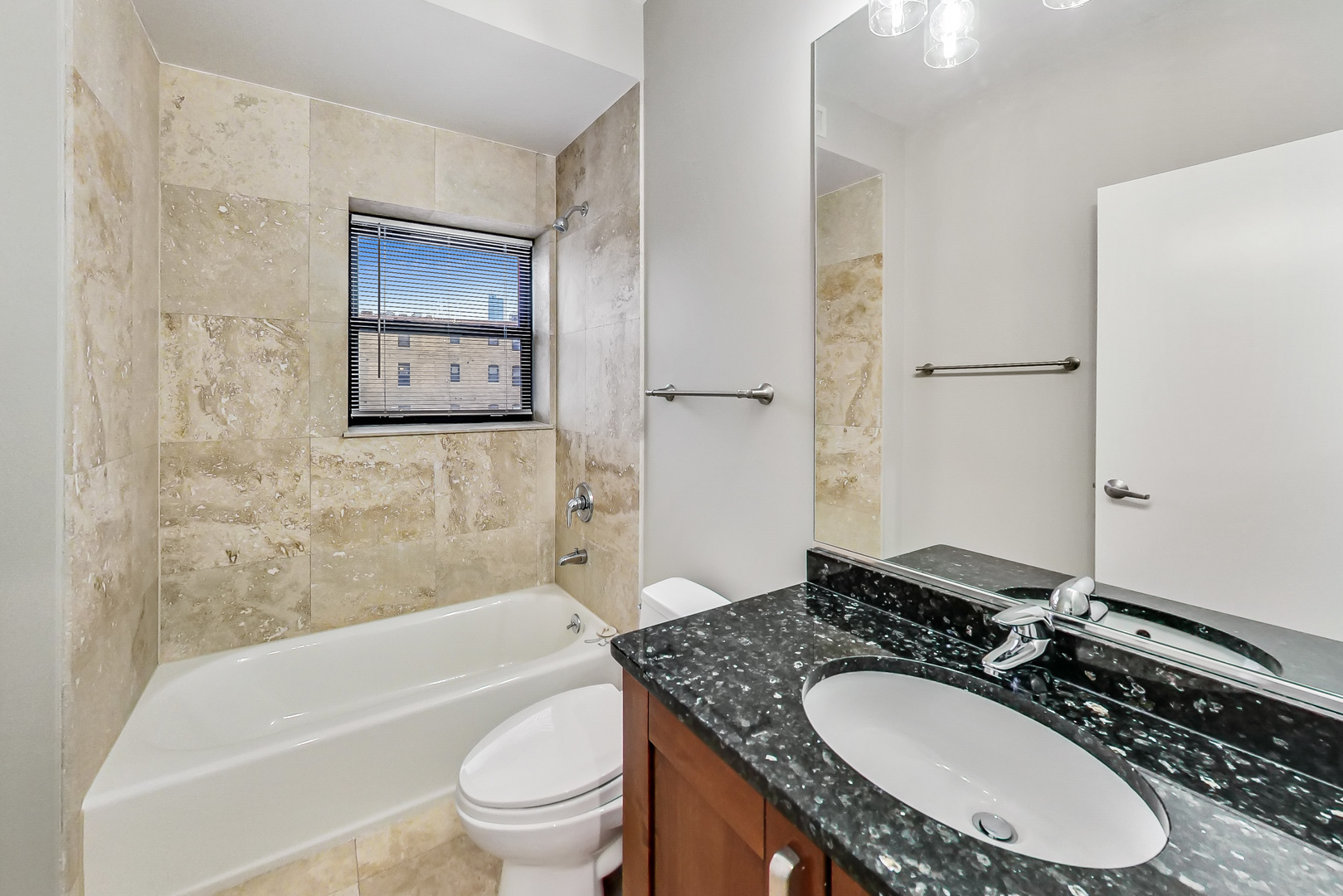 651 North Milwaukee Avenue, Unit 304 Chicago, IL 60642 - Photo 25 of 33 a bathroom with a granite countertop sink toilet and shower