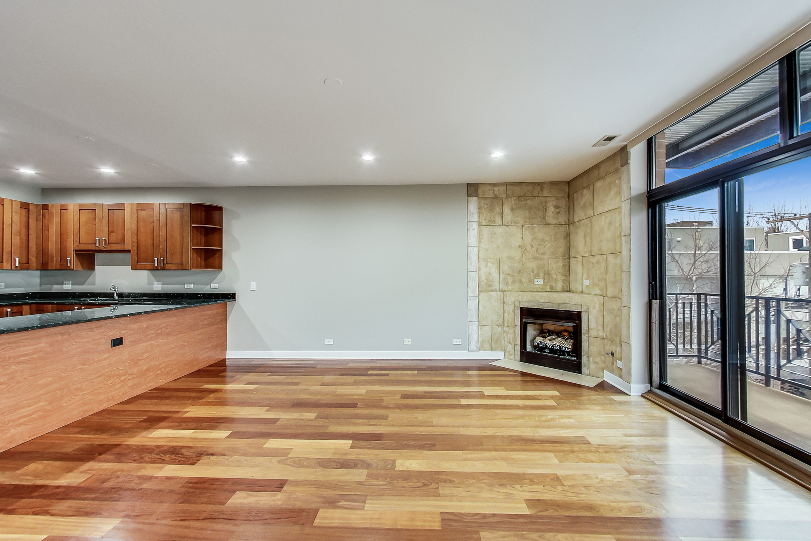 651 North Milwaukee Avenue, Unit 304 Chicago, IL 60642 - Photo 7 of 33 a view of kitchen with kitchen island a sink wooden floor and a fireplace