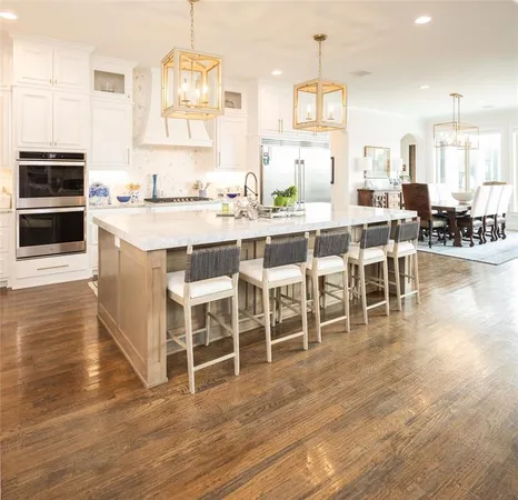 a kitchen with stainless steel appliances a dining table chairs stove and cabinets