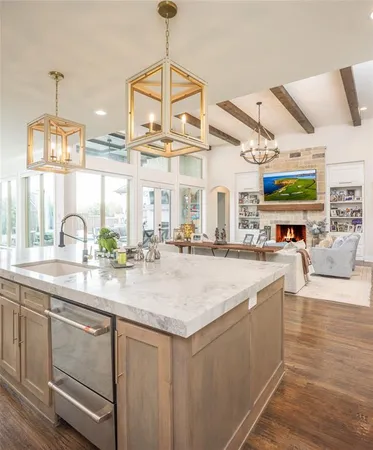 a kitchen with stainless steel appliances granite countertop a sink a counter space and living room view