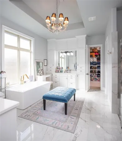 a living room with furniture a chandelier and a large window