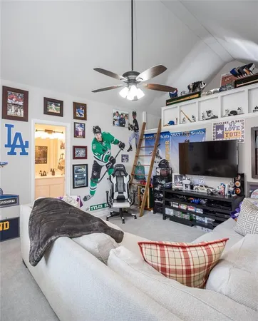 a bedroom with furniture a flat screen tv and a window