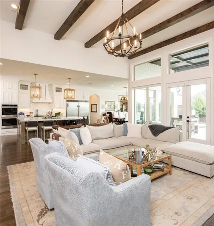 a living room with furniture kitchen view and large windows