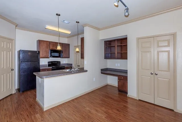 a kitchen with kitchen island a counter space a sink appliances and cabinets
