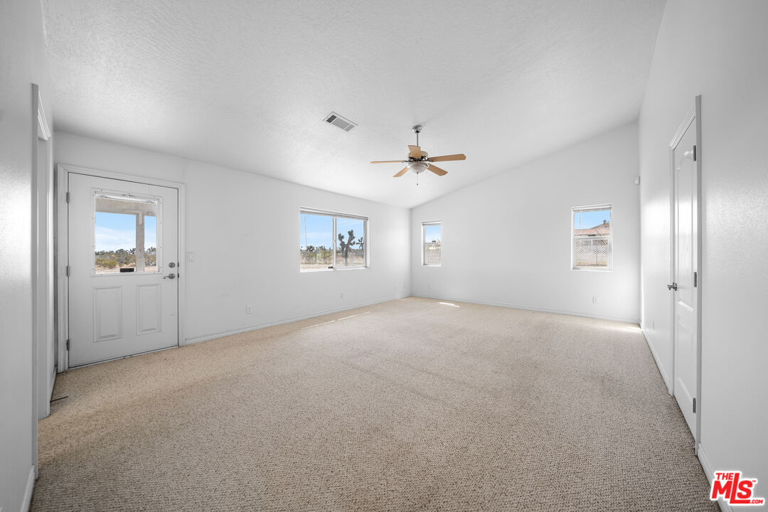 11635 Lebec Road Phelan, CA 92371 - Photo 15 of 35 a view of a big room with windows and chandelier fan