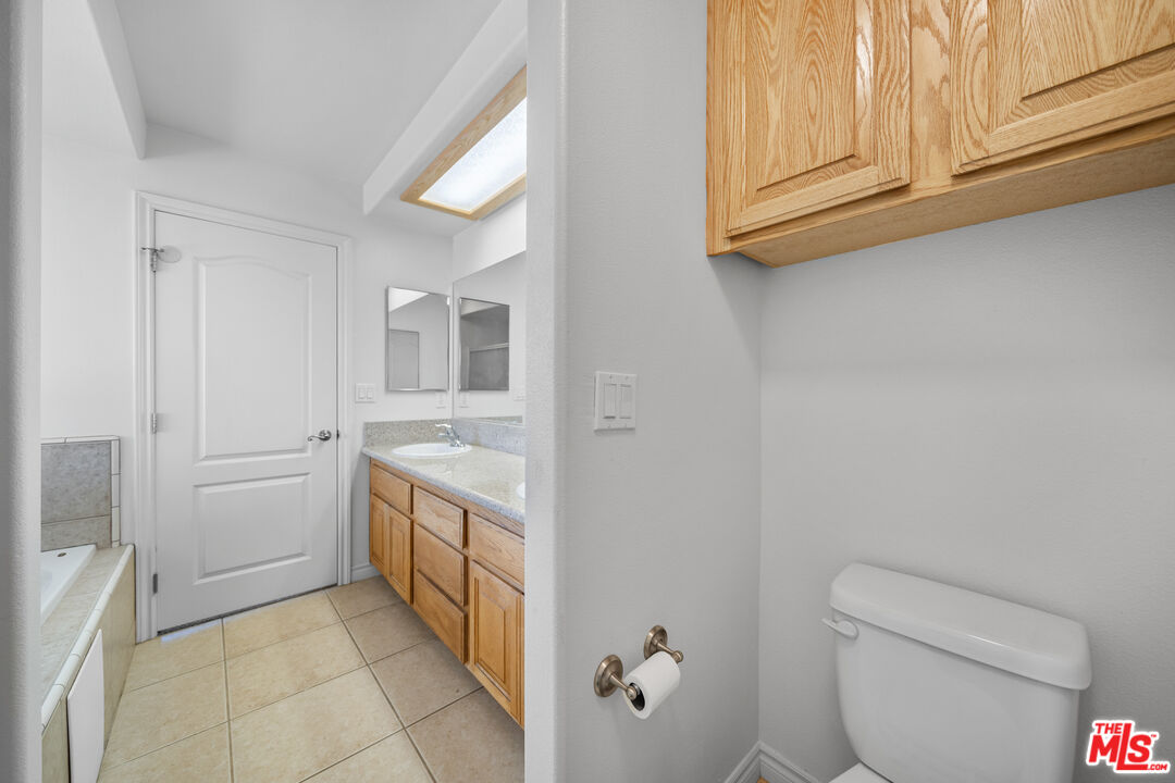 11635 Lebec Road Phelan, CA 92371 - Photo 18 of 35 a bathroom with a granite countertop sink and a toilet