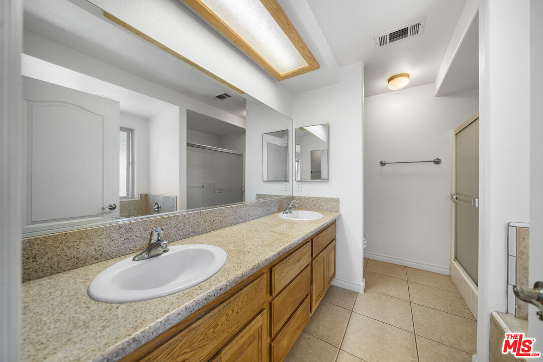 11635 Lebec Road Phelan, CA 92371 - Photo 25 of 35 a bathroom with a granite countertop sink and a mirror