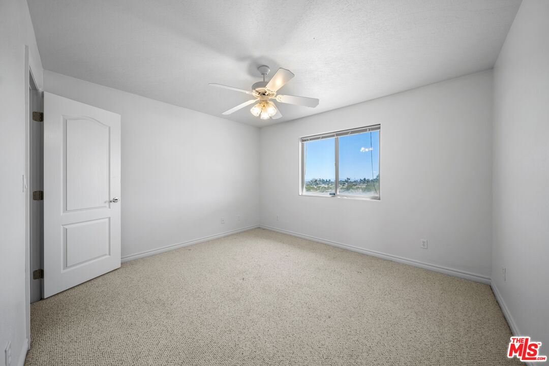 11635 Lebec Road Phelan, CA 92371 - Photo 26 of 35 an empty room with a window and a fan