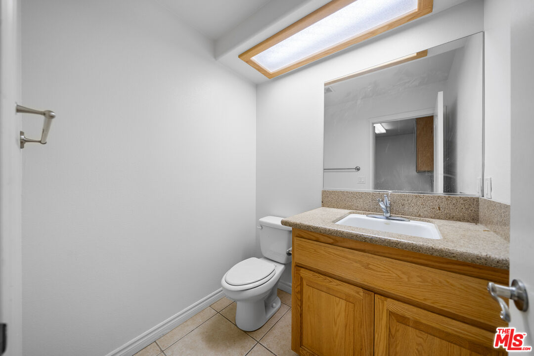11635 Lebec Road Phelan, CA 92371 - Photo 29 of 35 a bathroom with a granite countertop toilet sink and mirror