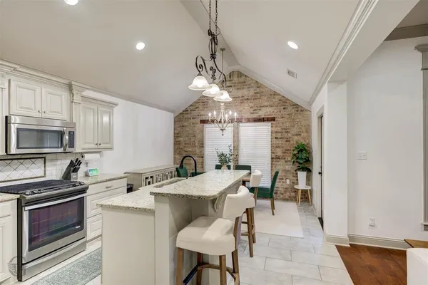 a kitchen with a table chairs stove and cabinets