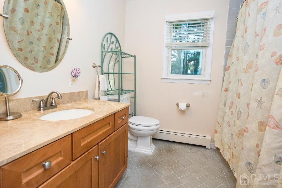 17 Ridgewood Avenue Monroe Township, NJ 08831 - Photo 12 of 16 a bathroom with a granite countertop sink mirror vanity and a toilet