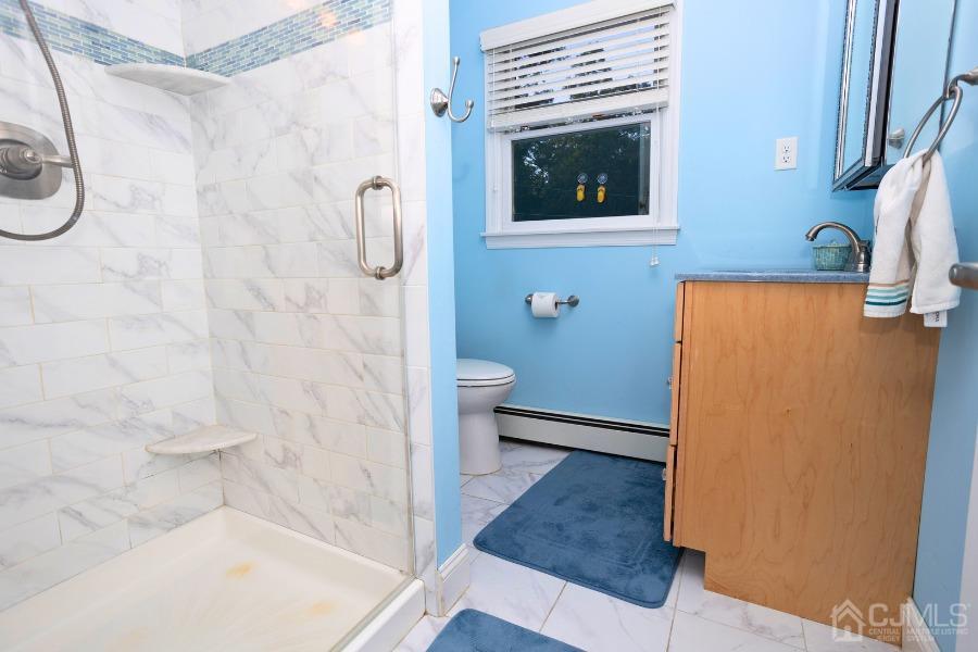 17 Ridgewood Avenue Monroe Township, NJ 08831 - Photo 10 of 16 a bathroom with a granite countertop shower a mirror and a toilet