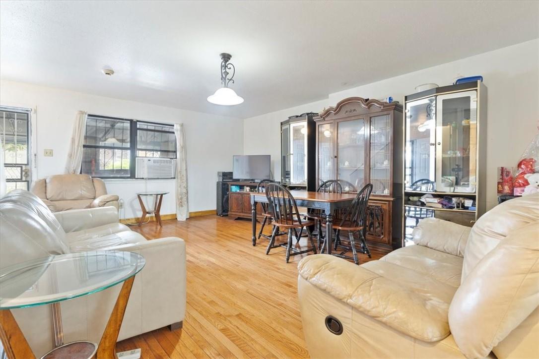 Living room with light hardwood / wood-style floors and cooling unit