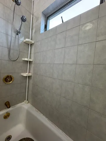 a bathroom with a bath tub with a shower