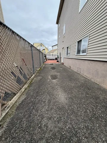 a backyard of a house with barbeque oven and wooden fence