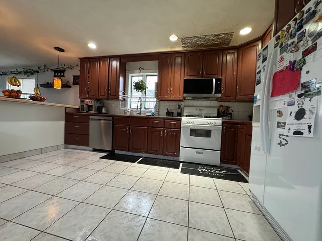 a kitchen with stainless steel appliances granite countertop a refrigerator and a stove top oven