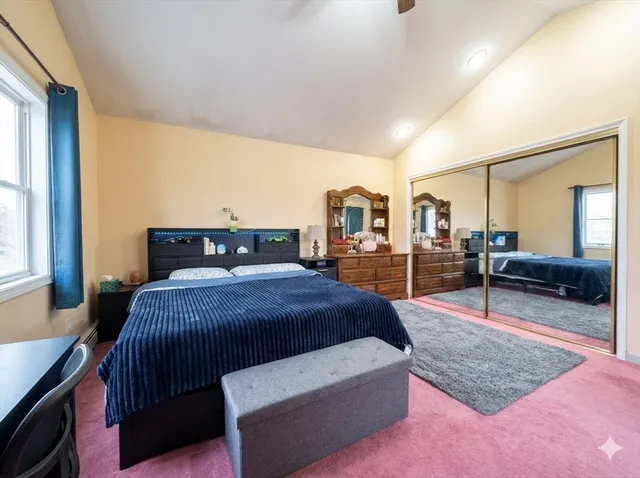 a bedroom with a bed a table and window