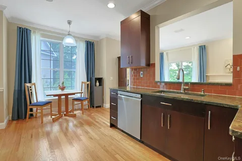 a view of an empty room with wooden floor fireplace and a window