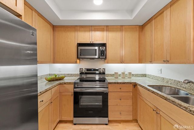 a kitchen with granite countertop cabinets sink and stove