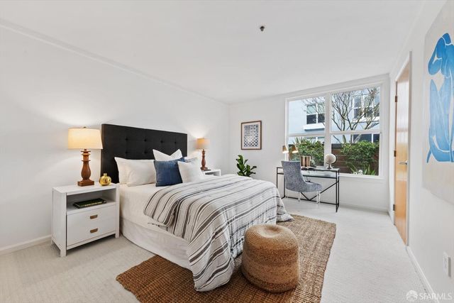 a spacious bedroom with a bed and wooden floor