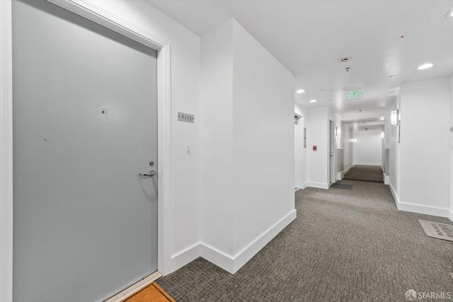 a view of a dining room and livingroom with furniture a rug a fireplace and a large window