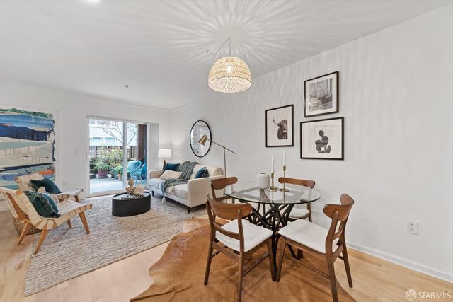 a view of a dining room with furniture a kitchen and chandelier
