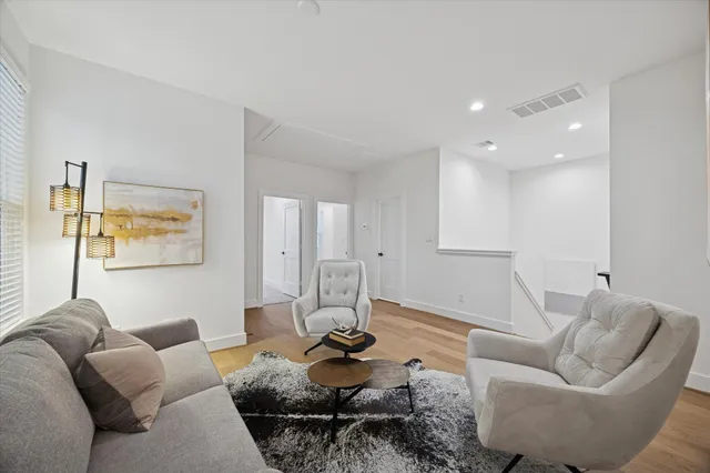 a bedroom with a bed lamps and a large mirror on the dresser