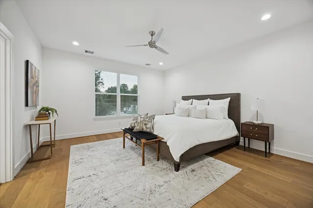 a bedroom with a bed and a wooden floor