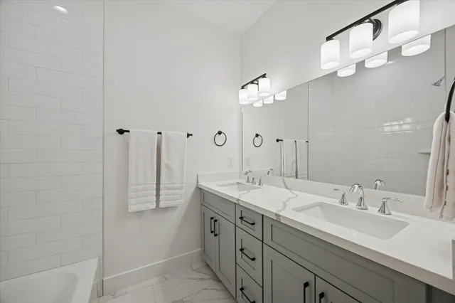 a bath room with a sink vanity tub and shower