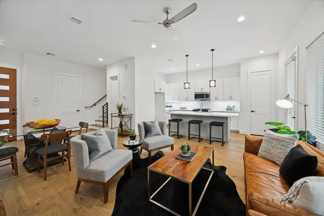 a living room with furniture kitchen view and a chandelier