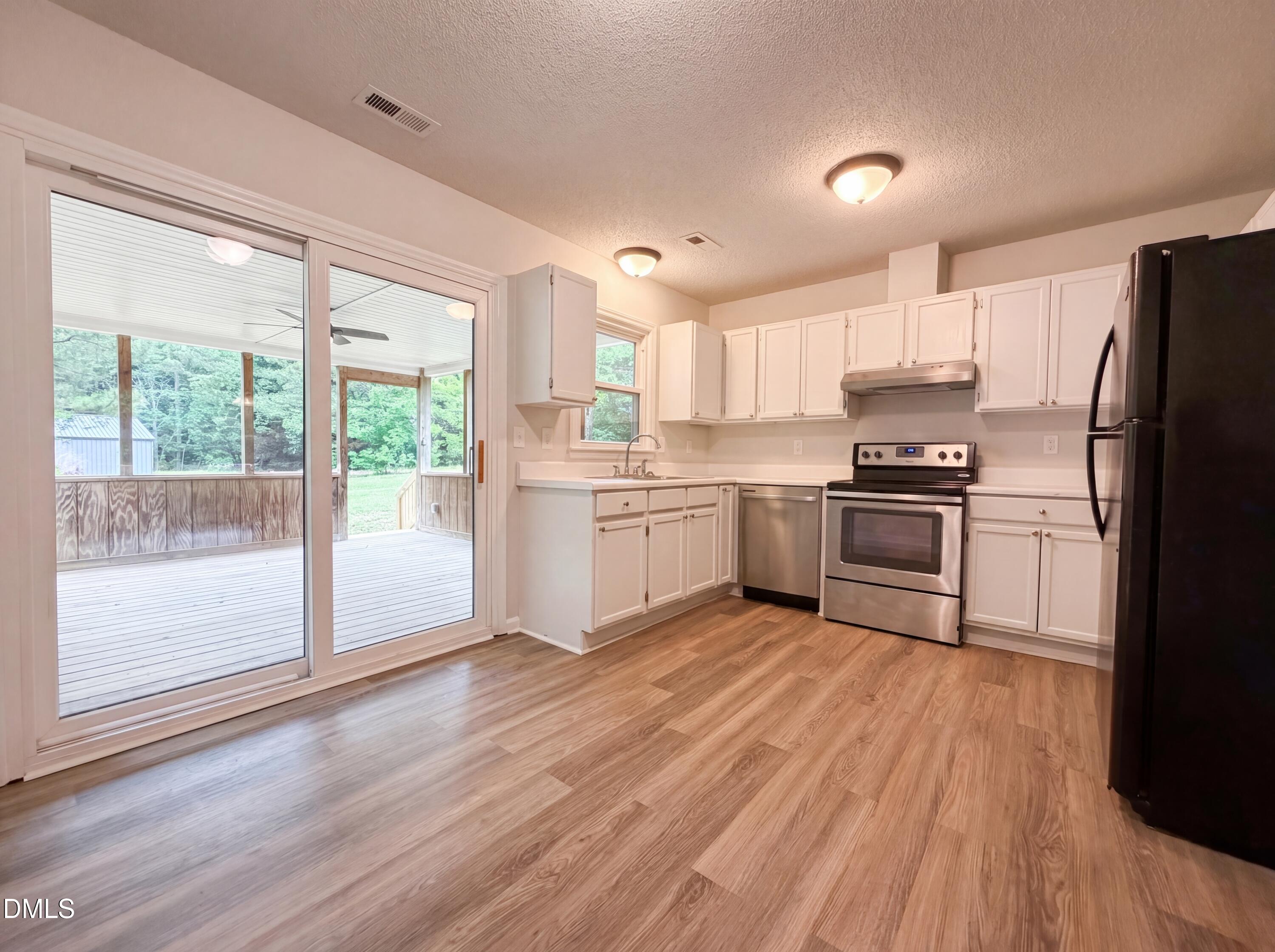 4894 Elevation Road, Unit C Benson, NC 27504 - Photo 8 of 24 a kitchen with wooden floors and appliances