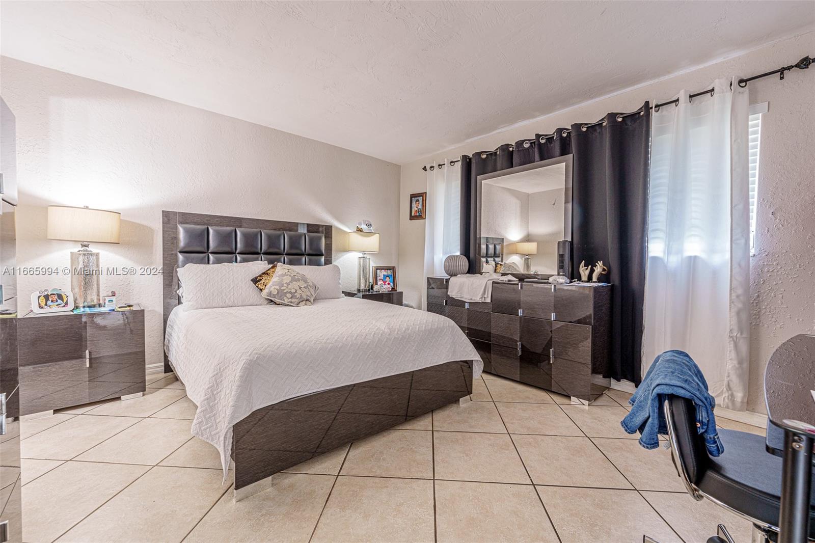 7410 Southwest 82nd Street, Unit K302 Miami, FL 33143 - Photo 20 of 34 a bed room with a bed and a chair