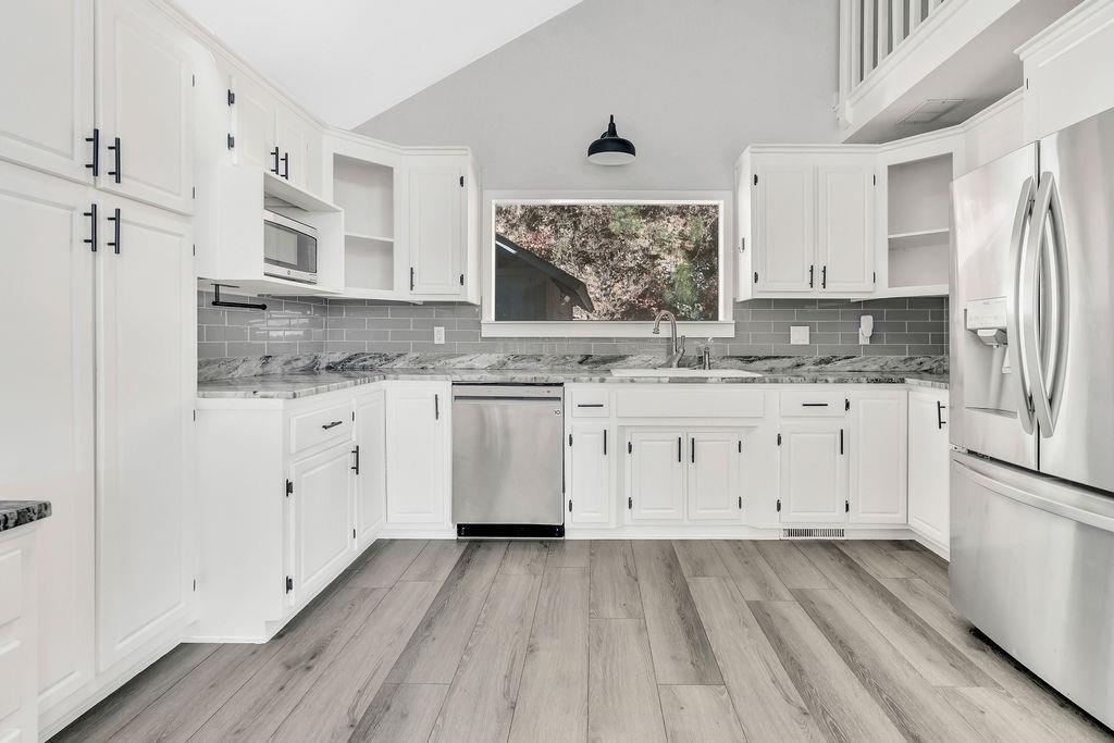 357 John's Way Talking Rock, GA 30175 - Photo 17 of 63 a kitchen with stainless steel appliances white cabinets a sink a stove a refrigerator and white cabinets