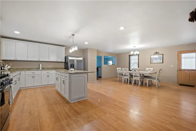 a large kitchen with cabinets table and chairs